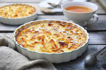 French cuisine. Apple flognarde (clafoutis), two portions and cup of tea - 584001922