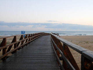 Fototapeta na wymiar Nice wooden bridge over the sand on the beach
