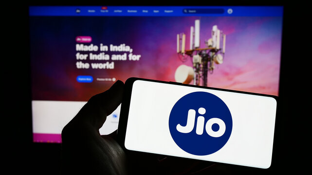 Stuttgart, Germany - 03-18-2023: Person holding smartphone with logo of Indian telecommunications company Reliance Jio on screen in front of website. Focus on phone display.