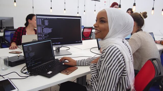 Islamic muslim programmer girl works at the computer. Developer hacker hasking the system