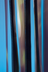 Veiled fragments of 35 mm film on blue background.