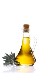 Organic olive oil in a glass jug with olive leaves on the side