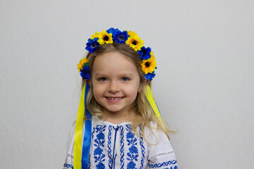 Little ukrainian blond girl on white background,smiling toddler in national ukrainian costume...