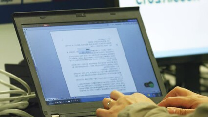 Employee works with text of script on laptop at workplace. Man modifies script for commentators in broadcast control room closeup