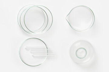 a set of laboratory glassware on a light background. Petri dishes, flasks, cups.