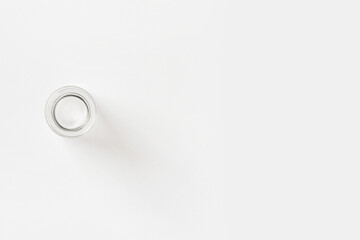 Empty small glass jar on a light background. View from above.