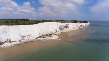 View along white chalk cliffs along English Channel coast on a sunny summer day . - 584014124