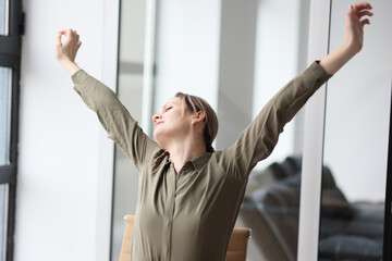 Woman stretches arms and back after monotonous work at table