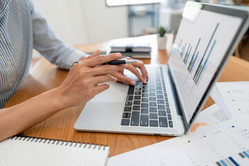 Fototapeta premium Hand holding pen pointing at laptop, online working corporate..