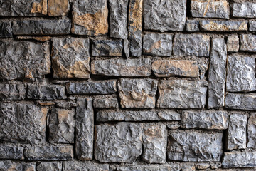 Texture stone wall with a rough surface, black and gray background, close up. Construction concept