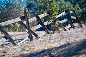 Old country fence broken and leaning dry dusty field with trees Agoura Hills California