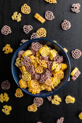Pasta of various scary shapes. Uncooked halloween pasta in bowl. Top view.