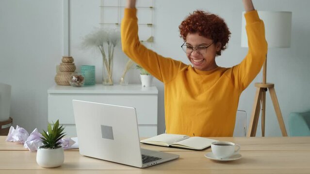 Excited happy african american woman euphoric winner. Girl student looking at laptop passed exam reading great news getting good result winning online bid feeling amazed at home. Winning gesture