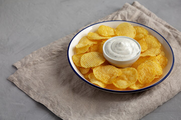 Tasty Potato Chips and Dip Appetizer on a gray background, side view. Copy space.
