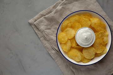 Tasty Potato Chips and Dip Appetizer on a gray background, top view.