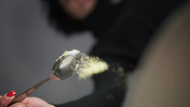 Woman hand is heavily salting something. Cook with spices, slow motion