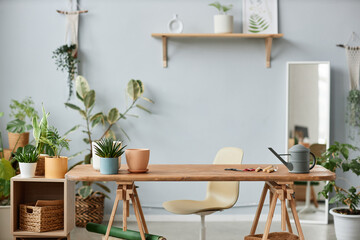Minimal background image of gardeners workplace indoors with live plants and wooden table, copy space