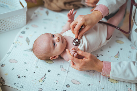 Pediatrician doctor examines newborn with stethoscope. Female doctor examines infant with stethoscope. Soft blur of the doctor hands use stethoscope to check newborn baby
