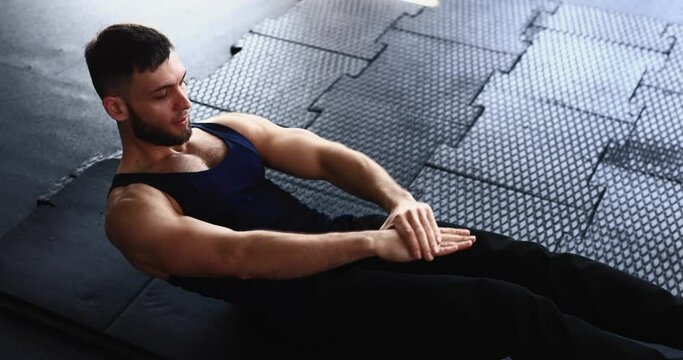 Man doing twist crunches for abs muscles at the gym