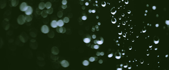 Atmospheric minimal monochrome backdrop with rain droplets on glass. Wet window with rainy drops and dirt spots closeup. Blurry minimalist background of dirty window glass with raindrops close up.