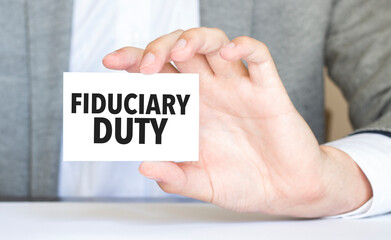 man's hand holding paper sheet with fiduciary duty words