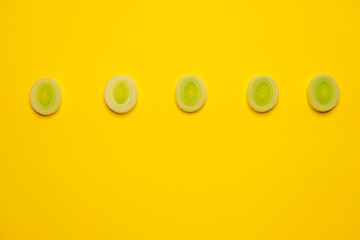 An organic Leek sliced on yellow background. Cool minimal flat lay, copy space. Healthy dieting concept