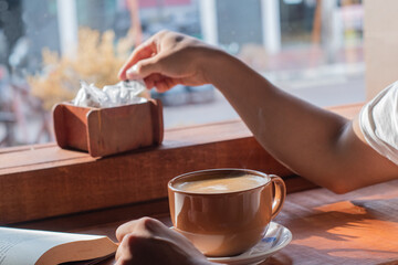 close-up of latin man with sweetener in his hand in a coffee shop about to drink his morning coffee.