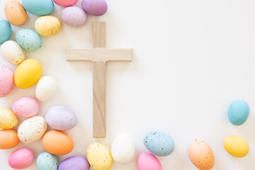 Wood cross and border of colourful Easter eggs on a white background