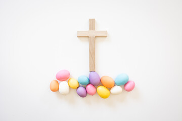 Wood Christian cross with easter eggs on a white background with copy space