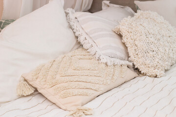 Decorative pillows on the bed in the bedroom as decoration of the interior and decor.