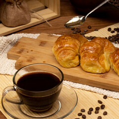 Uruguayan breakfast. Croissants with jelly. Spoon with pull Cup with freshly served coffee. Still life