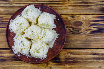 Traditional Turkish dessert Pismaniye on a wooden table. Top view