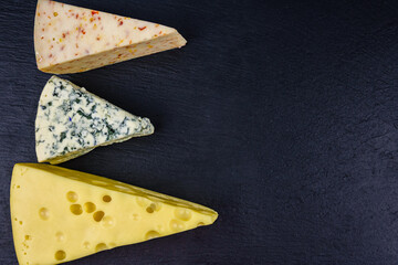 Various types of cheese on a slate board. Top view