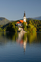 Fototapeta premium Front view of the iconic church on the island in Bled during september. Colorful autumn in Slovenia.