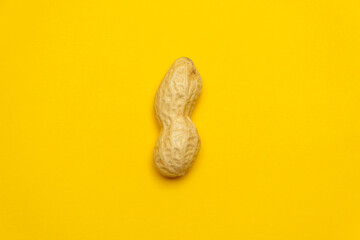 Whole peanut in shell on a yellow background. Protein and healthy dried fruit. Cool minimal flat lay, copy space 
