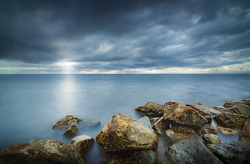 View of the lake from the boulders shore with impending rain and storm clouds at IJsselmeer Netherlands near the village Urk in Flevoland