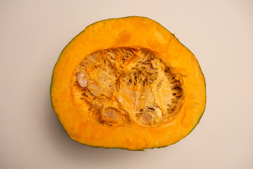 A juicy organic pumpkin cut in half on a white background. Seasonal food typical of autumn