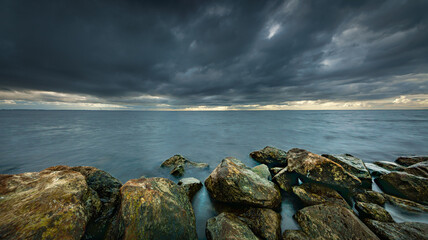 View of the lake from the boulders shore with impending rain and storm clouds at IJsselmeer Netherlands near the village Urk in Flevoland