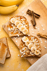 Homemade toasts with banana, honey and oatmeal closeup on a yellow background