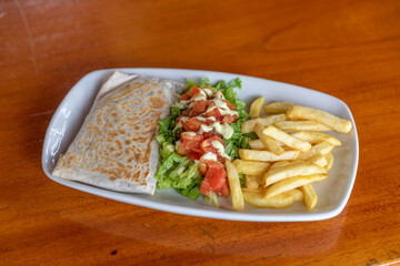 snack with a filled crepe, salat and frites on a plate