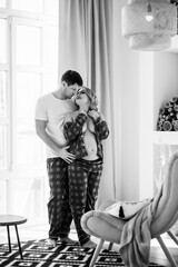 a pregnant woman and a man in pajamas in the home interior 