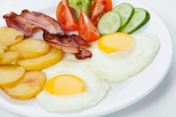 fried eggs with bacon and vegetables