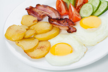 fried eggs with bacon and vegetables