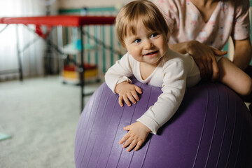 Massage for the baby. ten month old baby smiling doing gymnastics. Healthcare and medical concept.