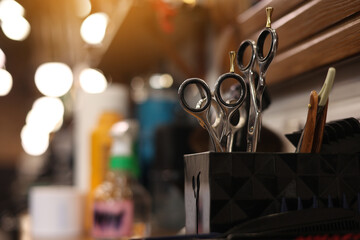 Professional hairdressing tools. Various steel scissors and combs, hairbrushes on wooden table on barbers workplace at barbershop salon. The concept of the hairdressing beauty industry. Copy space