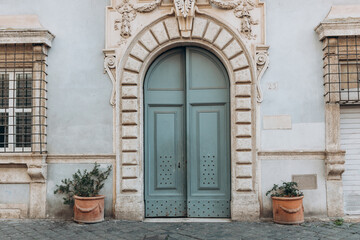 Fototapeta na wymiar Old street in historical town, beautiful old door with Plants decorations in Rome, Italy