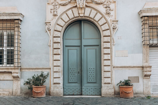 Fototapeta Old street in historical town, beautiful old door with Plants decorations in Rome, Italy