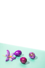 Minimal spring concept. Easter eggs and saffron flower on pastel blue and white background, hard shadows.