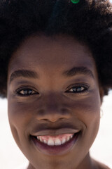 Closeup portrait of african american beautiful woman with afro hair smiling at beach