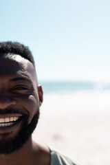 Cropped face of african american mid adult bearded man enjoying at beach against sea and clear sky